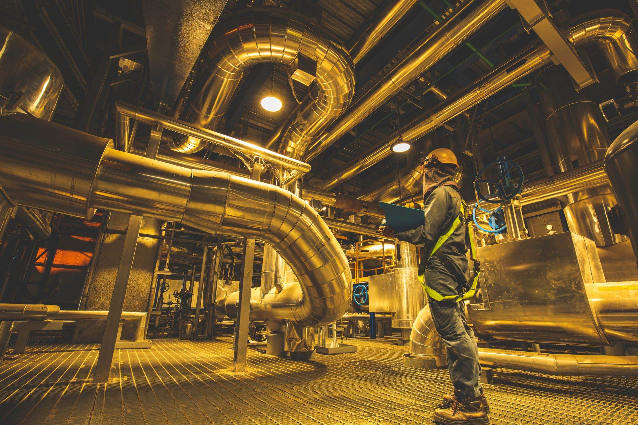 Engineer inspecting process piping inside a plant